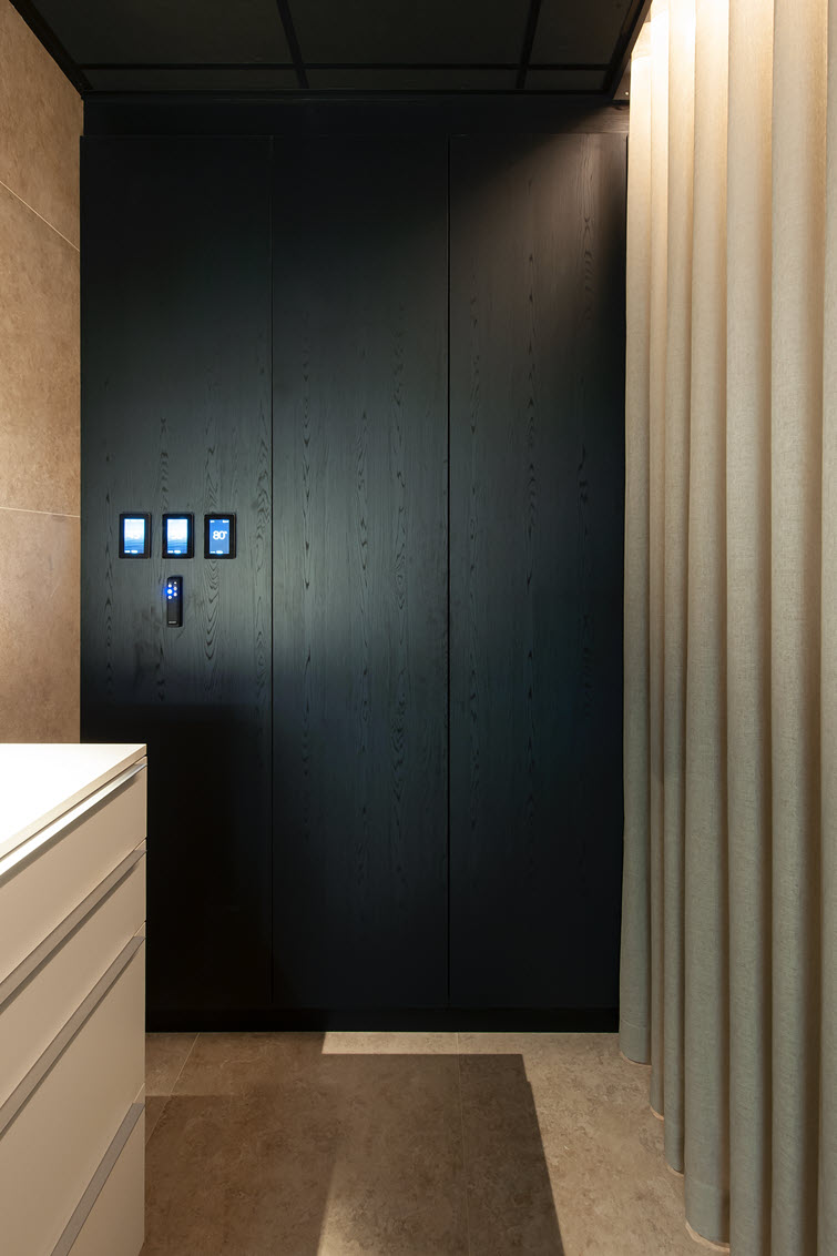 Black storage cabinets in the wellness area with synchronous Unilin Dainty Oak structure